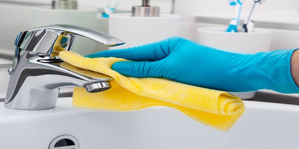 Sparkling clean bathroom basin being wiped down